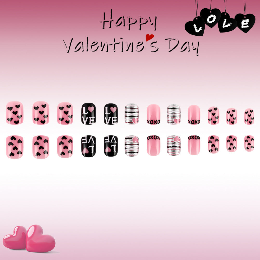 A collection of press on nails with a variety of designs including hearts and love messages to celebrate Valentine's Day, displayed in a gradient pink background.