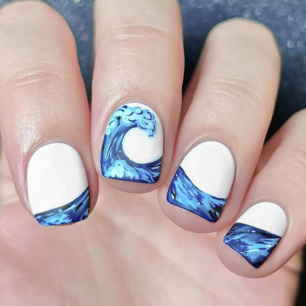 Nails with blue wave design on a white background
