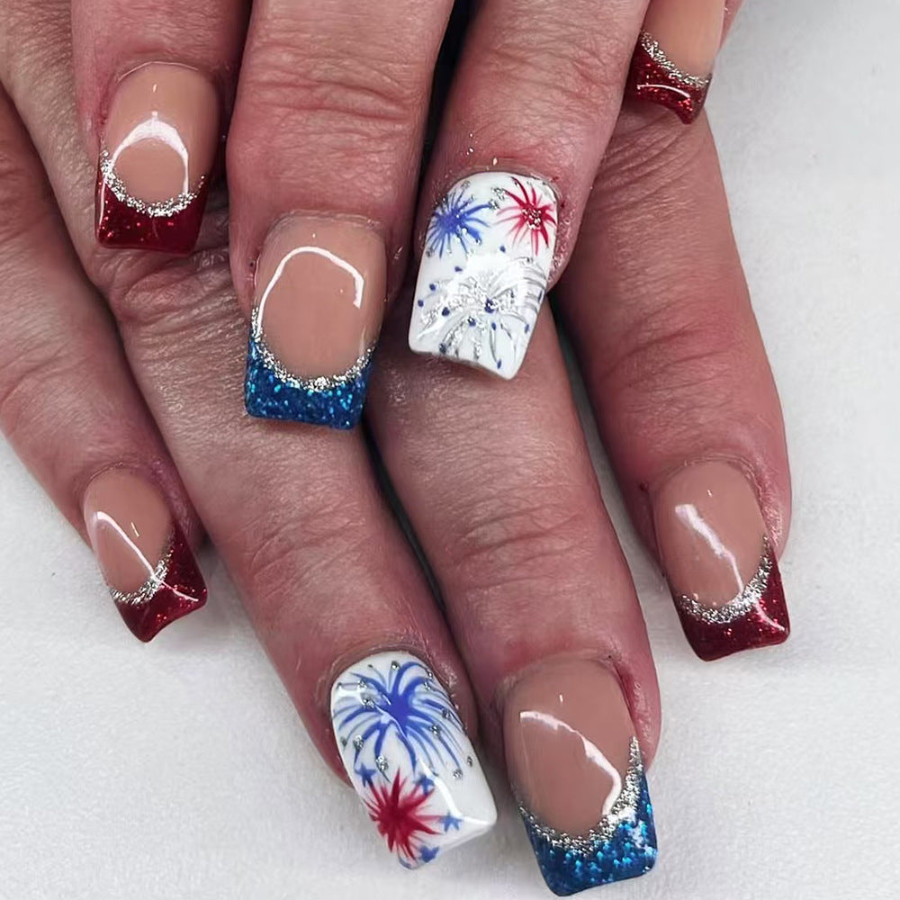 Nails with festive designs including red, white, and blue decorations on a white background