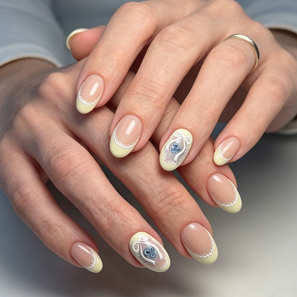 Whimsical Elegance Medium Round Yellow French Tip Press On Nail Set with Intricate Lace Design