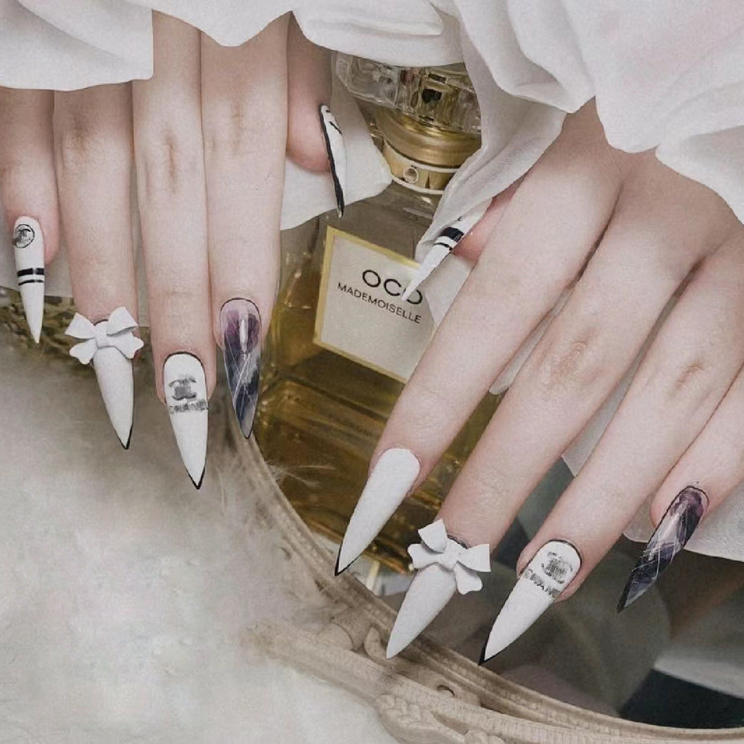 Chic Elegance Long Stiletto White Nails with Black Tips and Charming Bow Accents