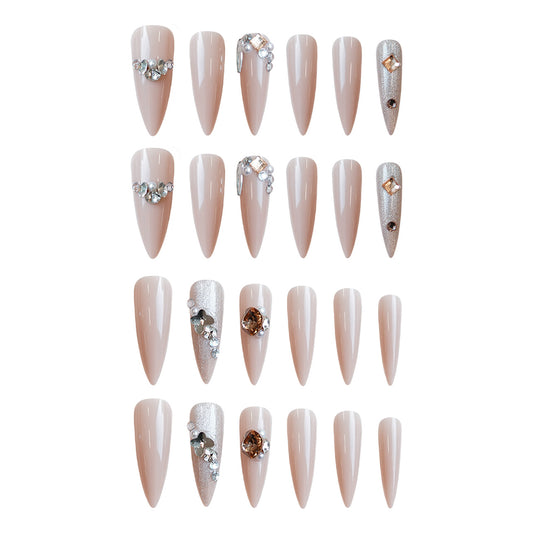 A collection of beige almond-shaped press-on nails, each featuring glimmering rhinestone accents in various designs.