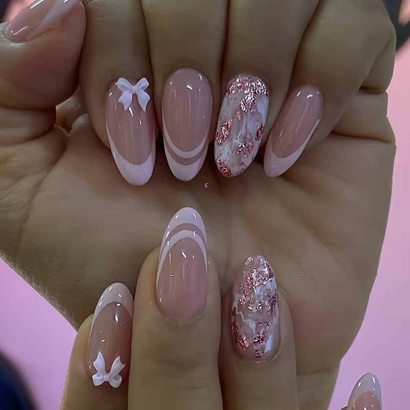 Close-up of a hand with pink and white nail art on a pink background