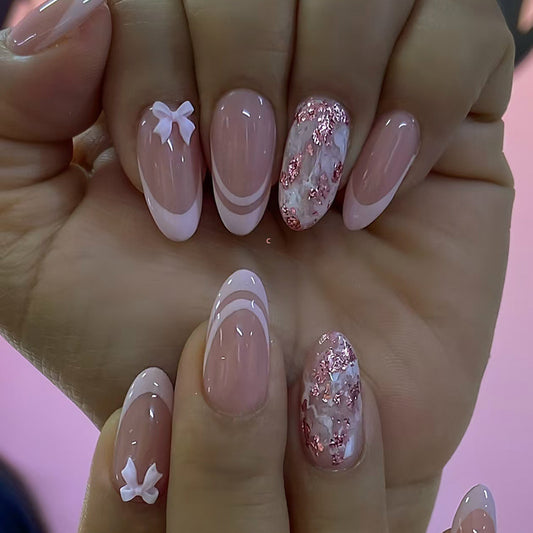 Close-up of a hand with pink and white nail art on a pink background