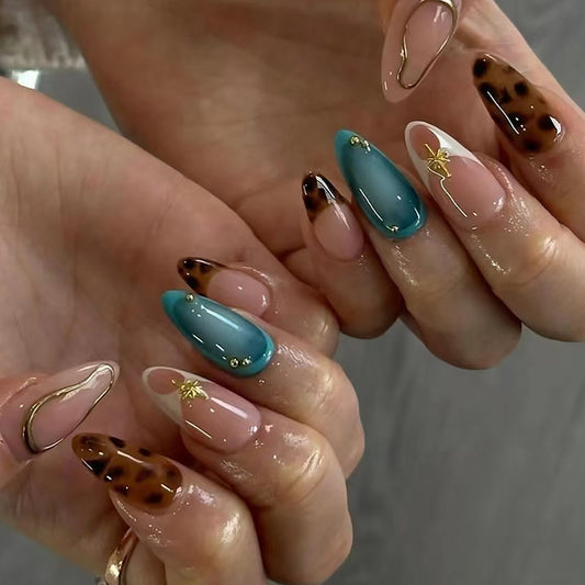 A set of long almond-shaped press-on nails with blue color and gold accents, featuring unique design elements.