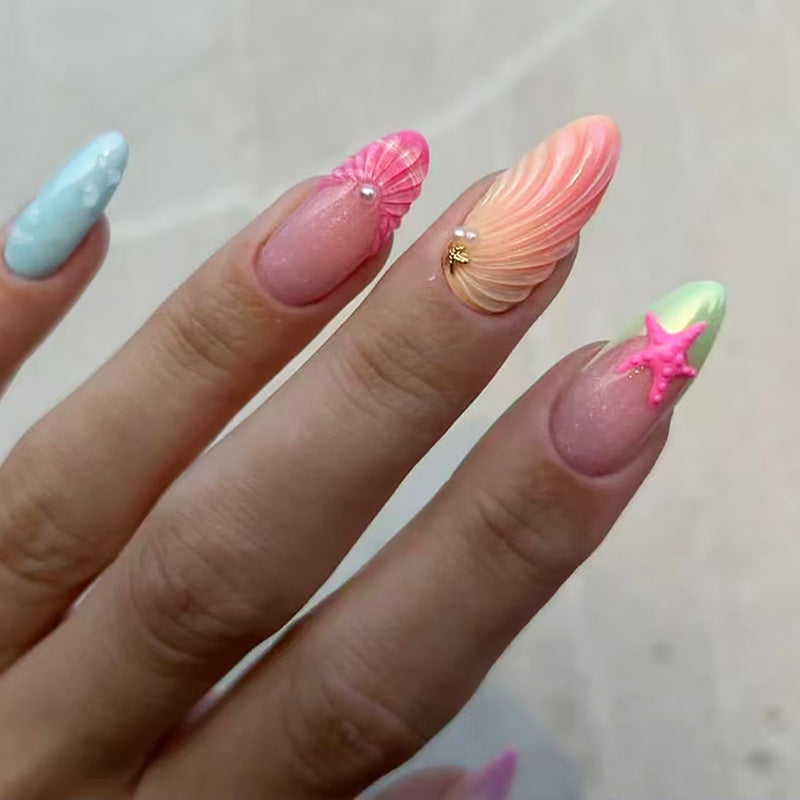 A set of press-on nails featuring a variety of pastel colors and decorated with starfish and shell designs.