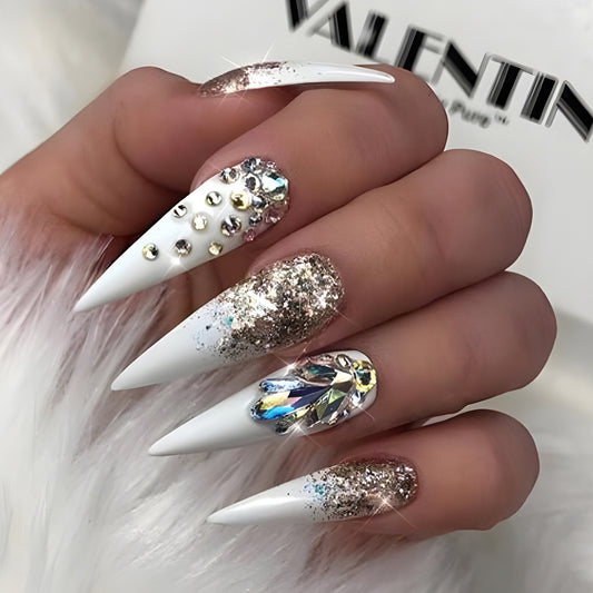 Glamorous Gala Long Pointed Stiletto White Nails with Gold Foil Flakes and Jewel Embellishments