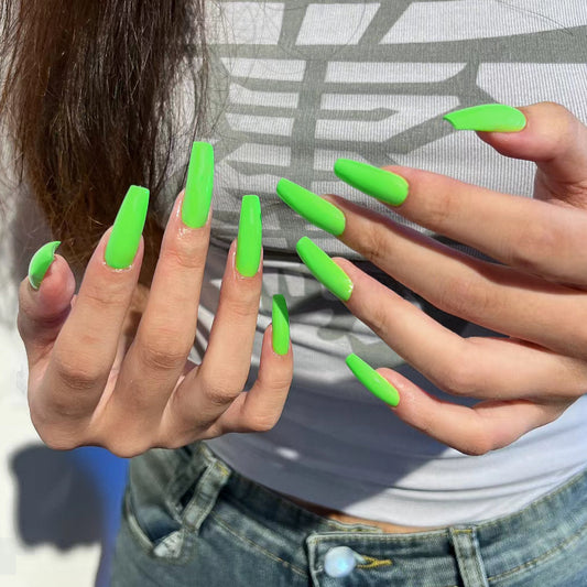 Close-up of hands with bright green nails against a neutral background
