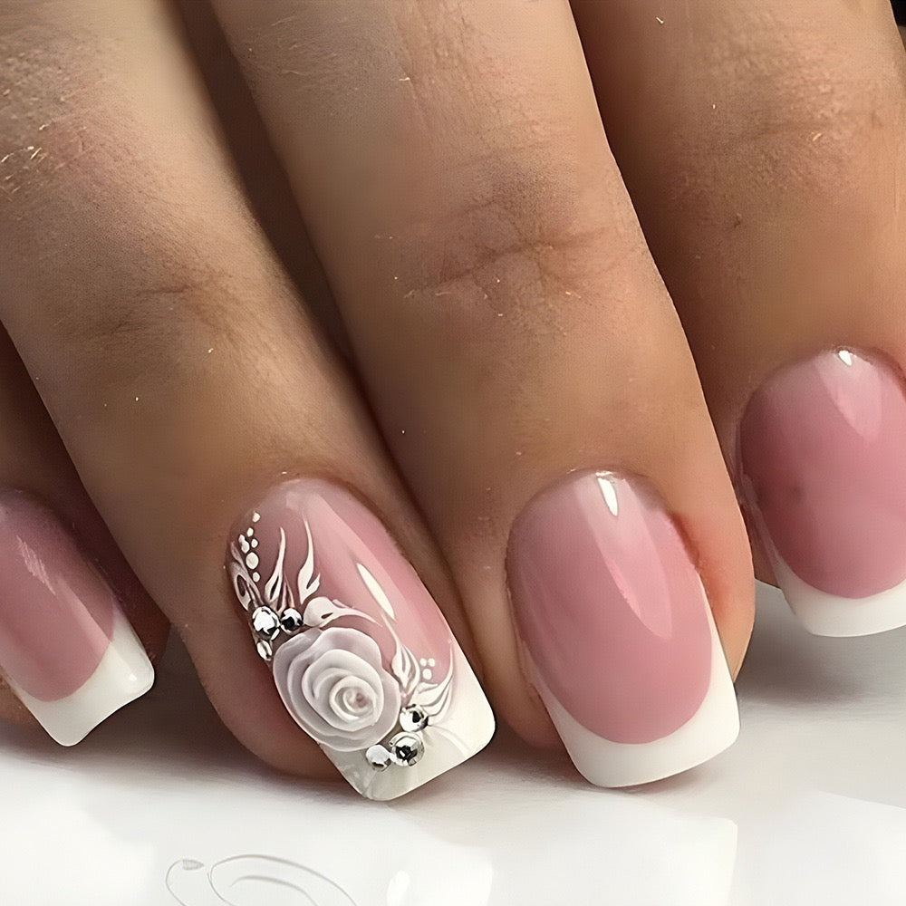 Close-up of a hand with pink and white nail design featuring a rose.