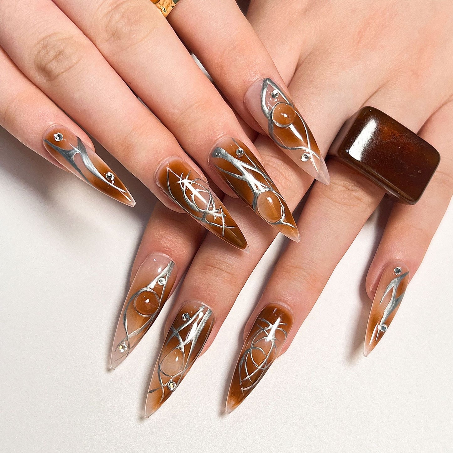 Chic Elegance Extra-Long Stiletto Caramel Swirl Press-On Nails with Silver Detailing and Gem Accents