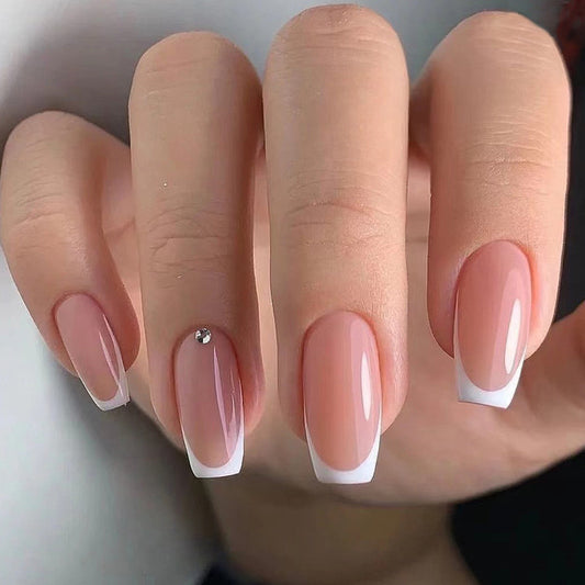 Close-up of a hand with pink and white gradient nails on a neutral background