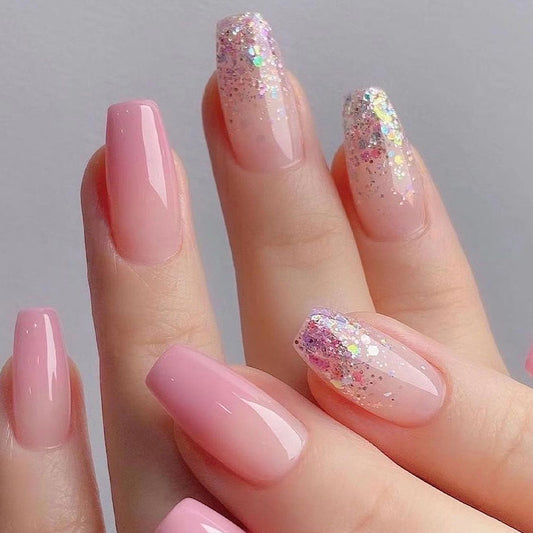 A set of press-on nails featuring a Coffin nail shape with a pink glitter design.