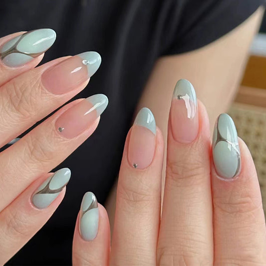Close-up of hands with light blue and silver nail art on a blurred background