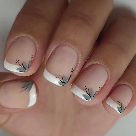 Nails with white and gray floral design on a neutral background