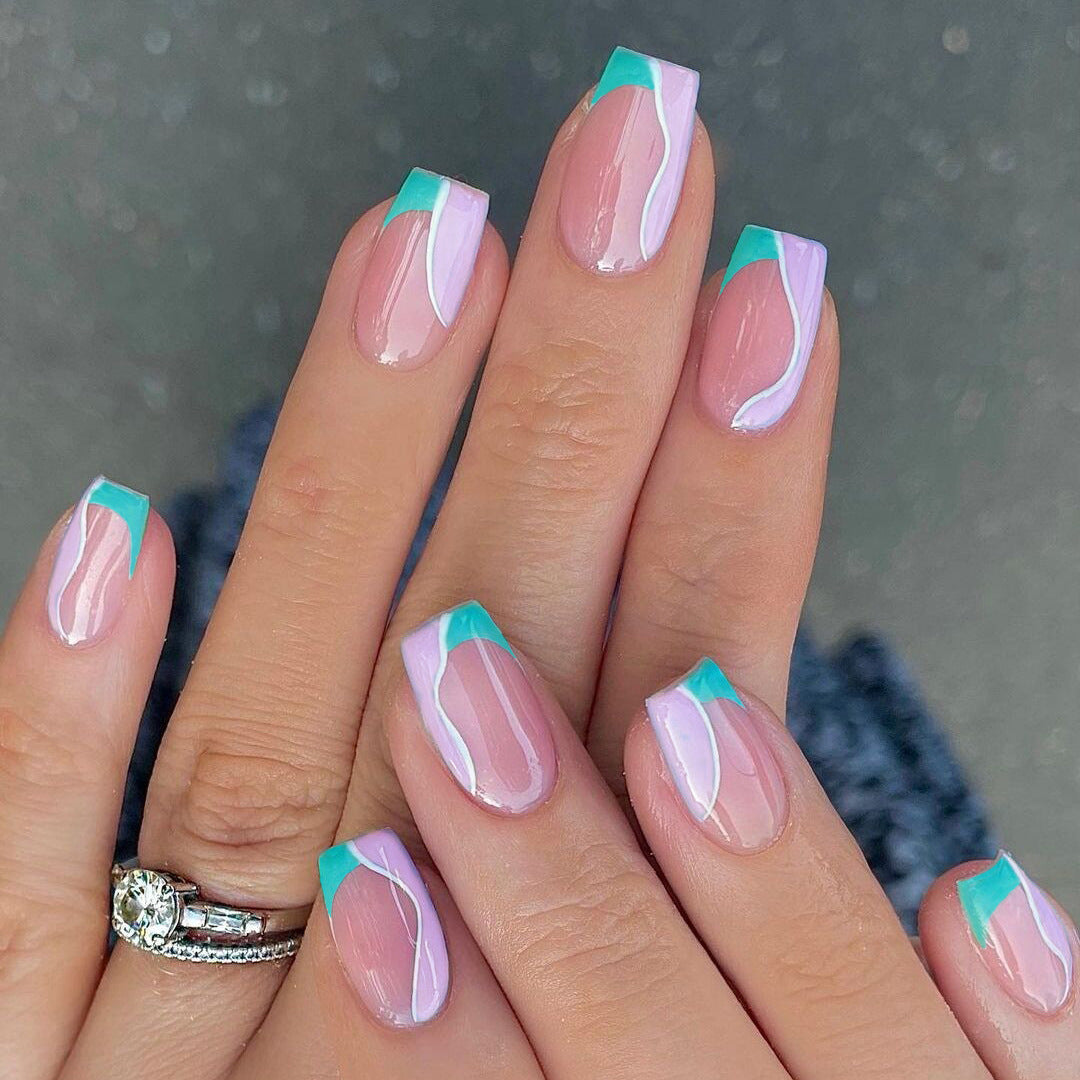 Nails with pink and teal design on a neutral background