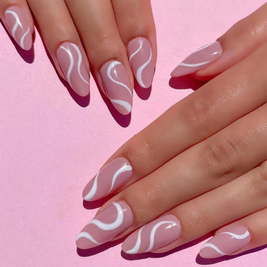 A person's hands showcasing almond-shaped pink nails with a white wave pattern design.