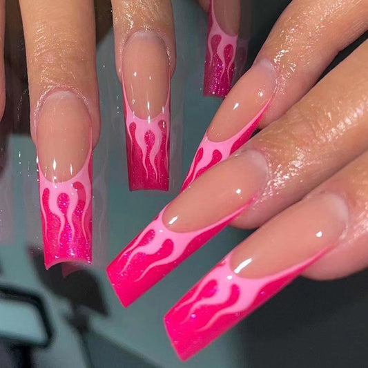 A set of pink press-on nails with flame accents, designed to be worn on fingernails.