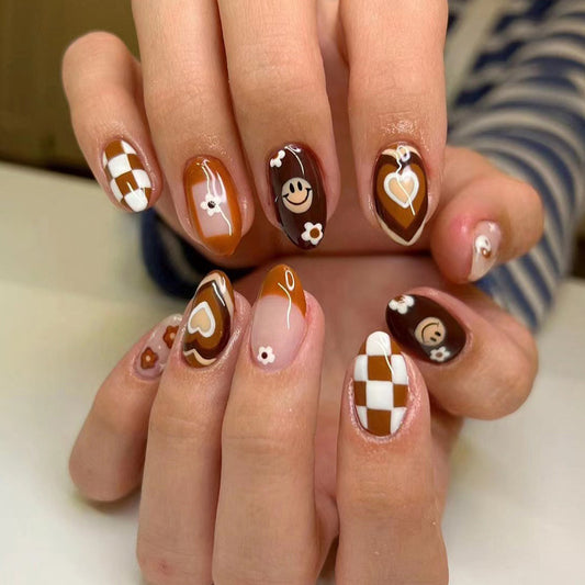 Nails with brown and white design on a neutral background