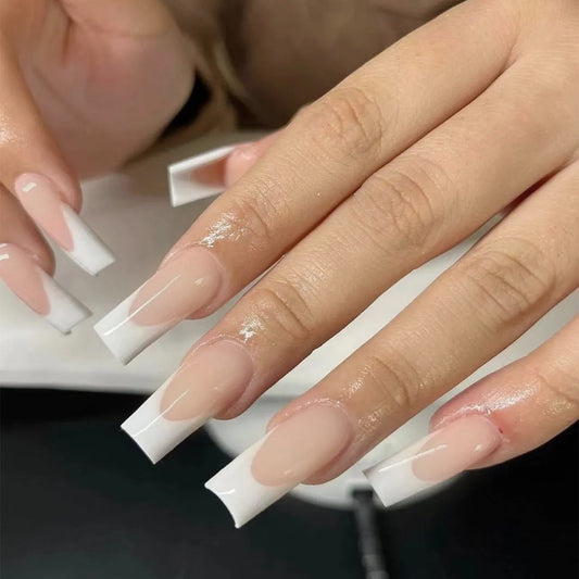 A pair of long square white French tips press-on nails.