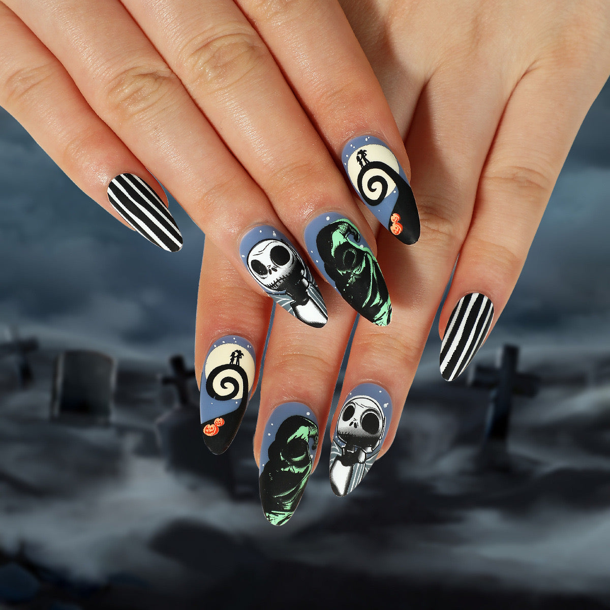 A set of press-on nails featuring designs from the Nightmare Before Christmas movie, applied to almond-shaped nails against a Halloween-themed background.