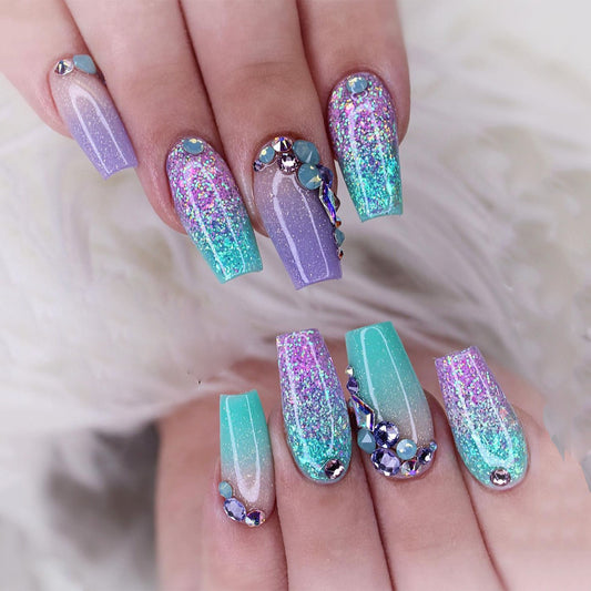 Multicolored glittery nail design on a hand with a soft white background