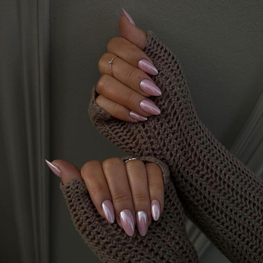 Brown fingerless gloves worn by a person with pink nail polish on a dark background