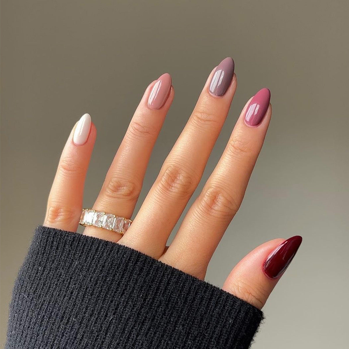 A collection of long almond-shaped press-on nails in various multicolor ombre shades, glossy finish.