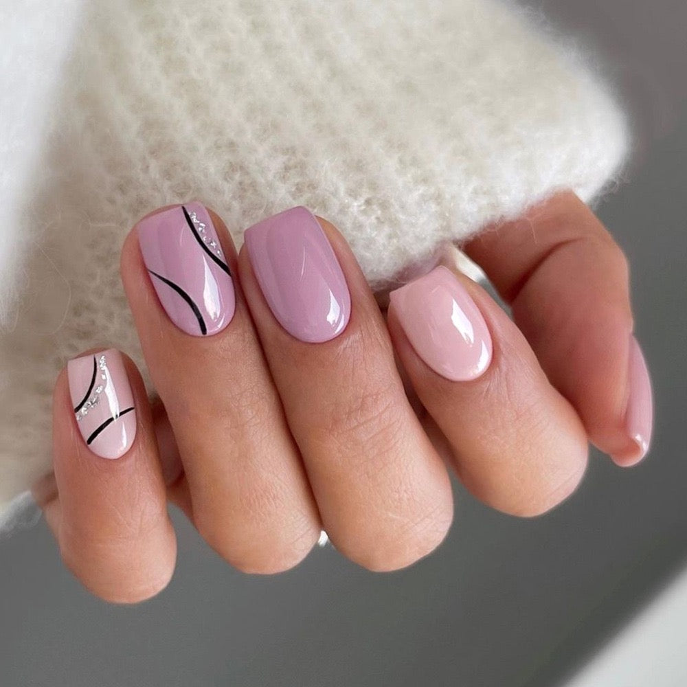 A hand with short square purple press-on nails with a pinkish glossy finish.