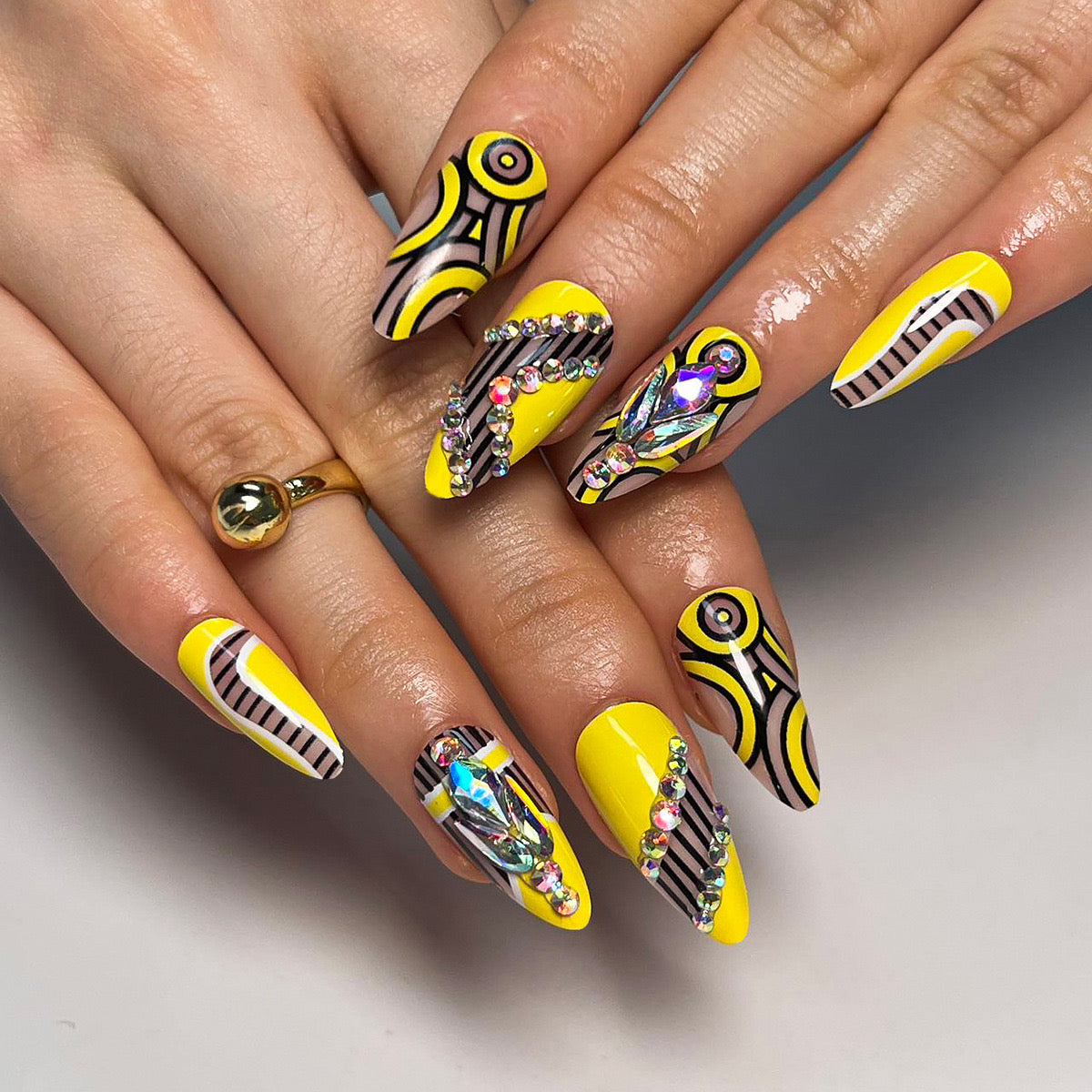 Psychedelic Sunshine Long Almond Vibrant Yellow Press-On Nails with Hypnotic Black Patterns and Crystal Accents