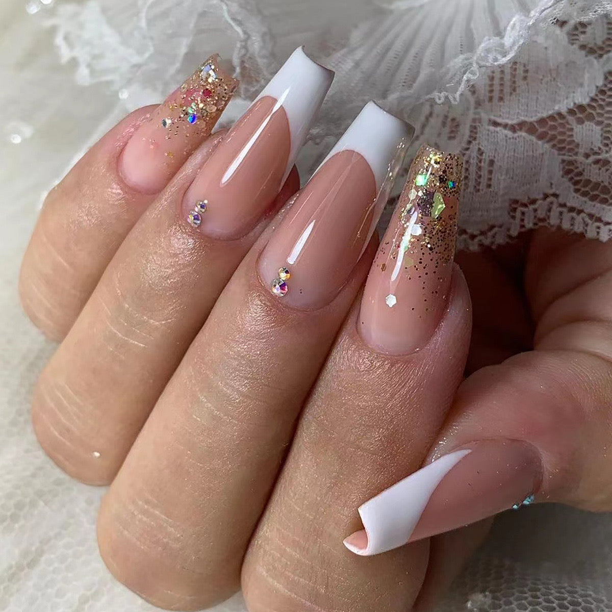 Medium Length Coffin French Tip Press-On Nails with Beige Base, White Tips, Gold Glitter Accents, and Rhinestone Embellishments