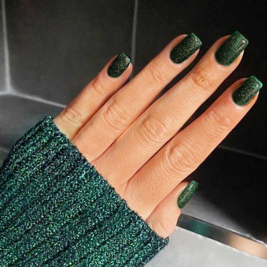 A hand wearing medium square green glitter press-on nails.