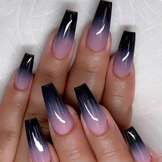 A set of long, coffin-style press-on nails featuring a gradient color transition from black to purple with a high gloss finish.