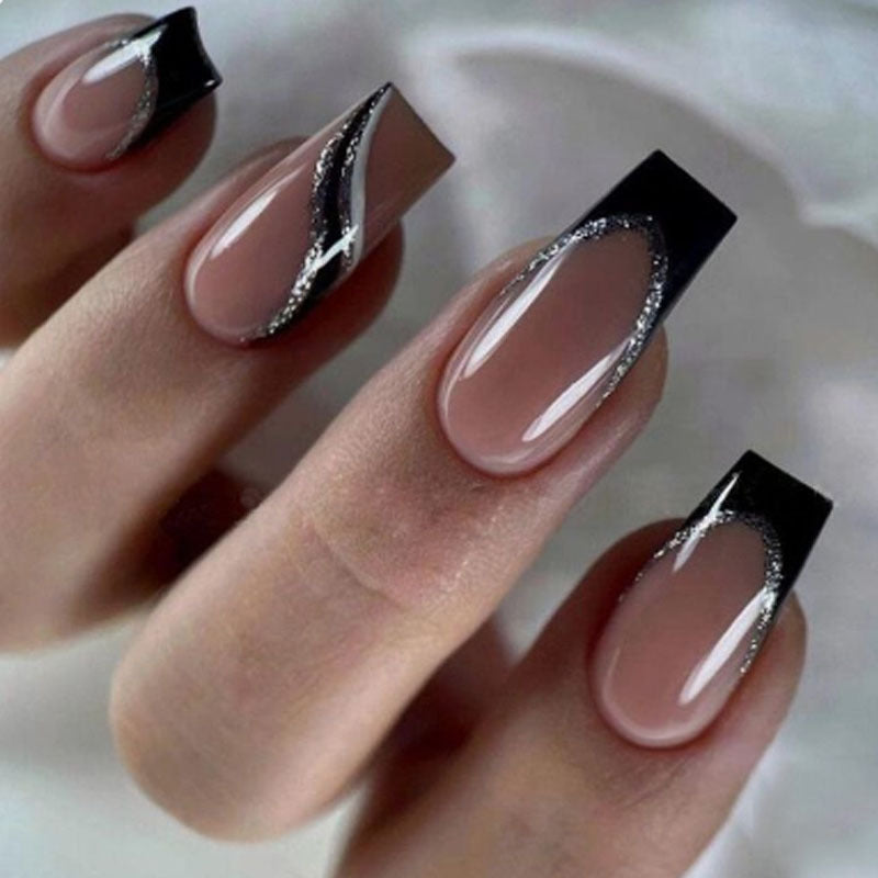 Nails with black and silver design on a neutral background