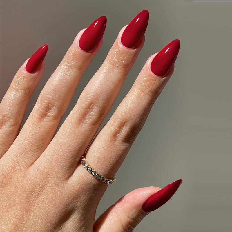 Hand with red nail polish on a neutral background