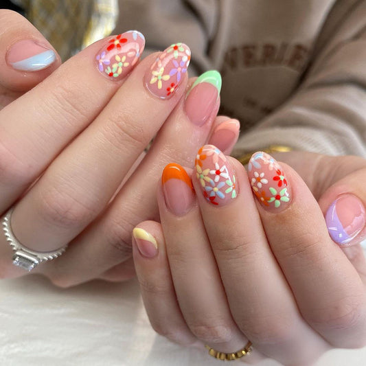 A set of colorful, floral patterned press-on nails featuring a variety of bright colors.