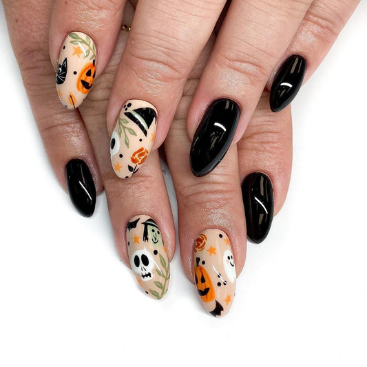 A set of press-on nails featuring a Halloween theme with black and orange colors, showcasing designs such as skulls and pumpkins.