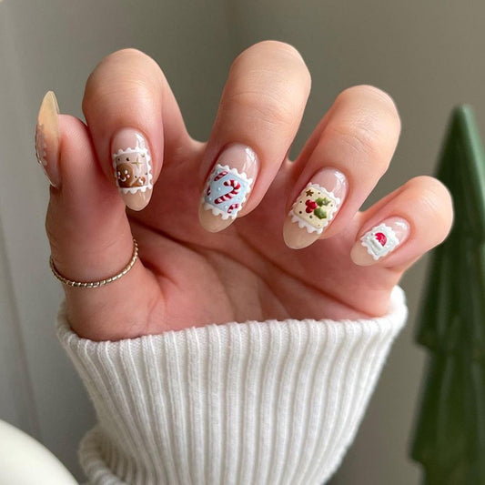 Hand with Christmas-themed nail art wearing a white sleeve.