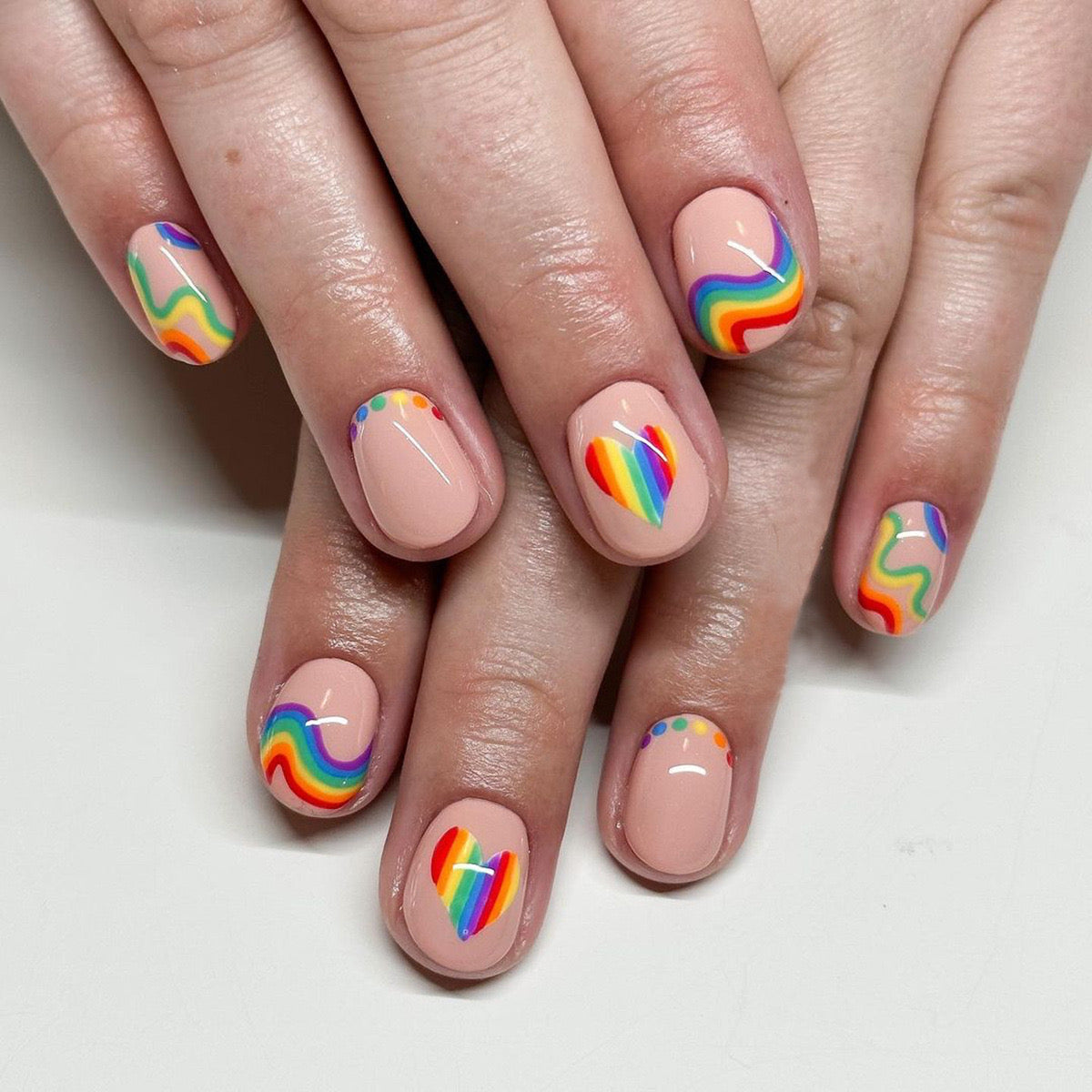 Vibrant Spectrum Short Oval Beige Press-On Nails with Rainbow Swirls and Accents for Playful Charm