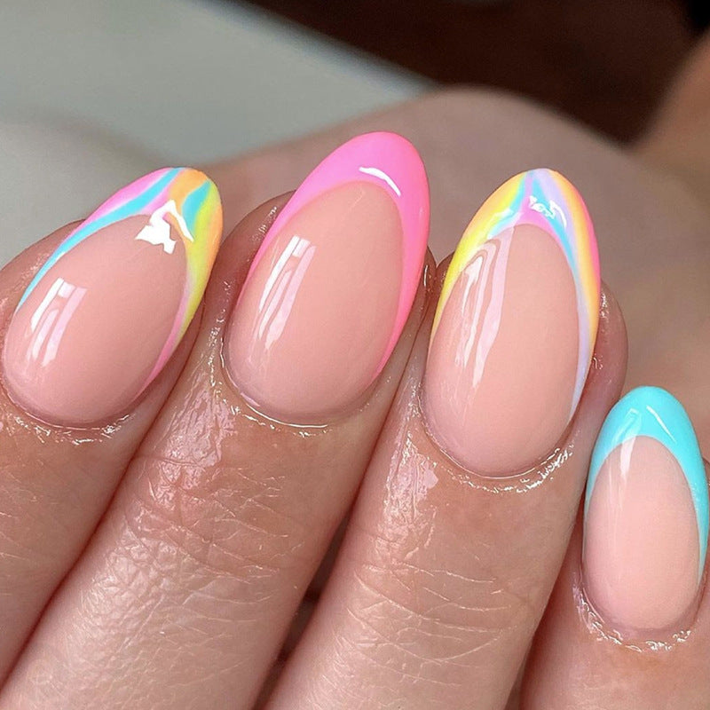 A set of press-on nails featuring an almond-shaped design with a French tip and a multicolored rainbow gradient.