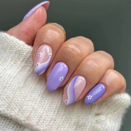 Hand with purple and pink gradient nails on a neutral background