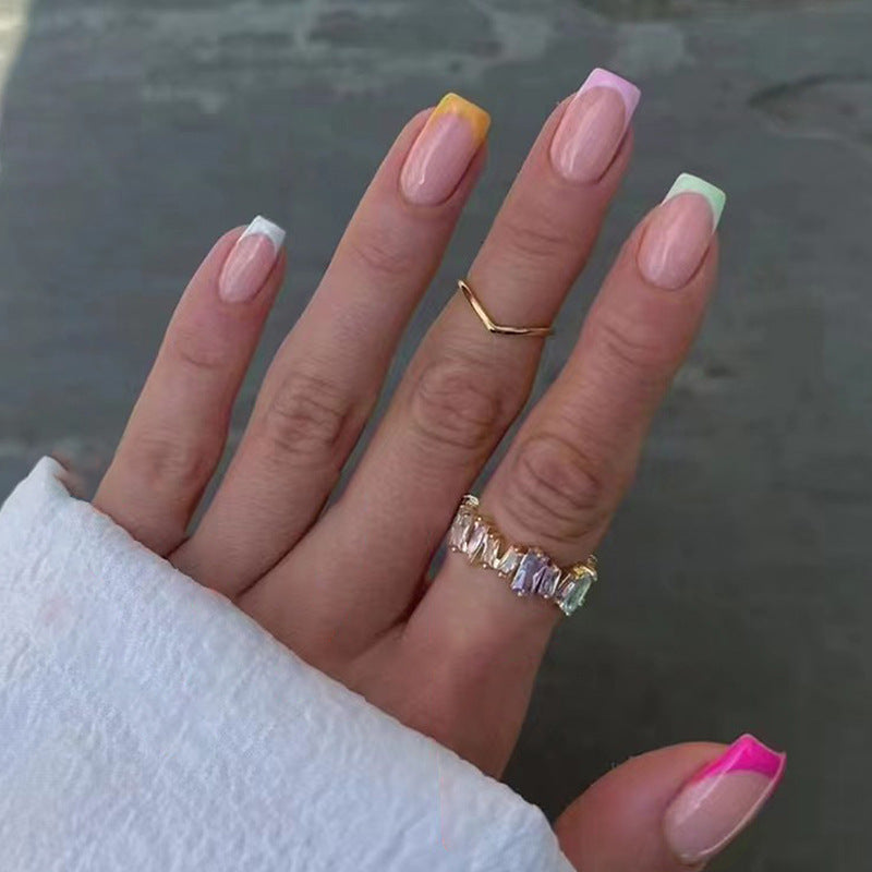 Hand with colorful nail polish and rings on a blurred background