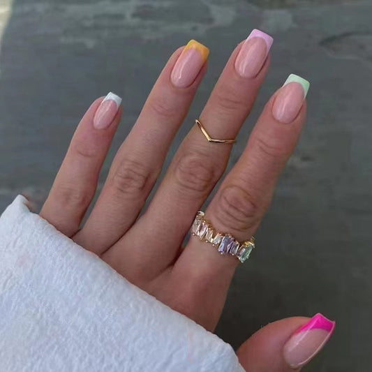 Hand with colorful nail polish and rings on a blurred background