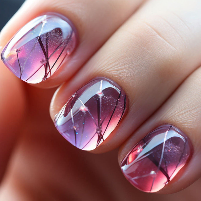A close-up image of press-on nails with a squoval shape featuring a purple floral design.