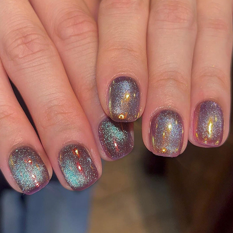 A photo showing a person's fingernails with short squoval purple glitter press on nails.