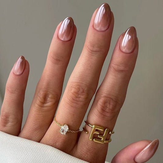 Hand with gold rings on a neutral background