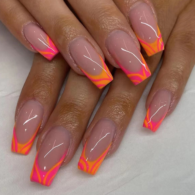 A set of press-on nails with vibrant pink and orange tips, presented on a hand.