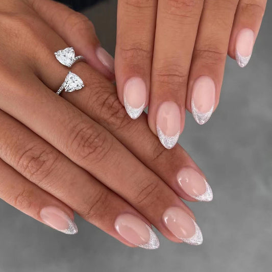 A set of press-on nails featuring an almond shape with a French tip design, in medium length, with silver accents on the tips.