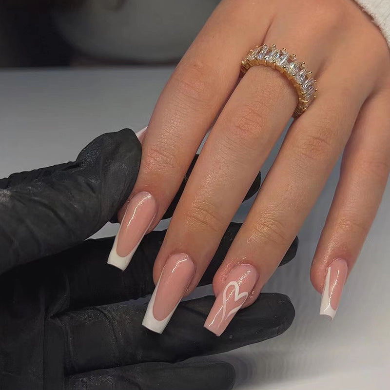 Hand with pink nail polish and a diamond ring, wearing black gloves on a neutral background
