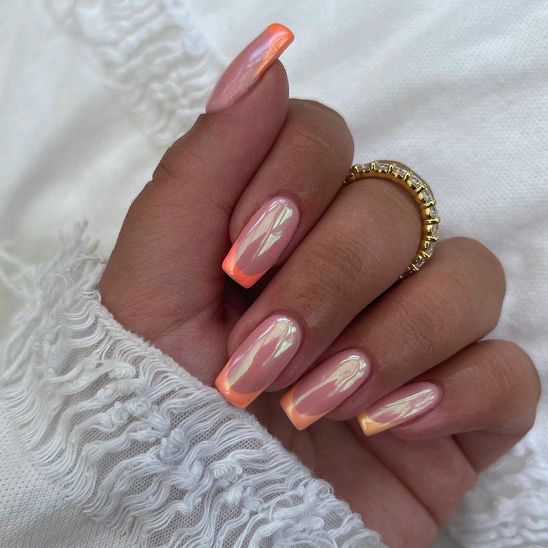 Hand with pink and orange gradient nails on a white lace background