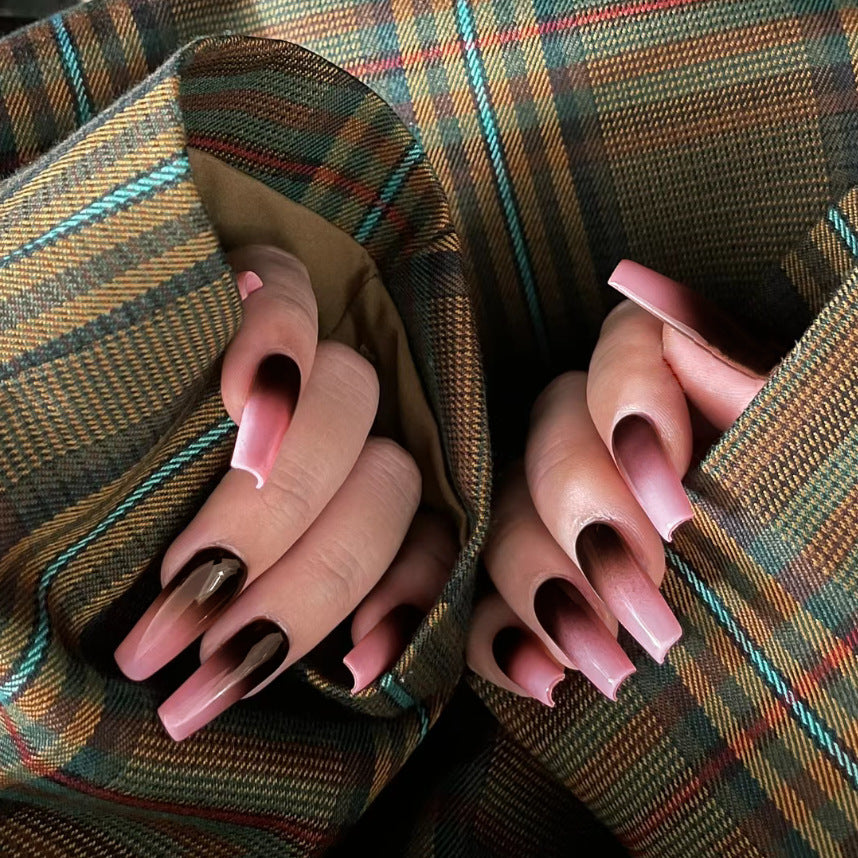 Set of false nails displayed against a plaid fabric background